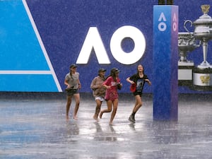 Children run in the rain at Melbourne Park