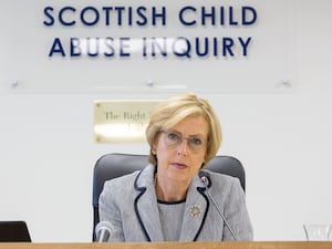 Lady Smith under a sign reading Scottish Child Abuse Inquiry