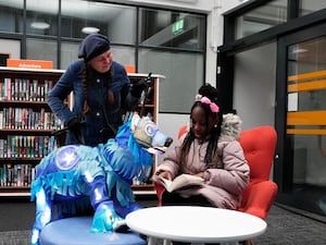 Alex McCormick and Pearl Ogunyadeka, 10, reading a book inside Spellow Community Hub and Library in Walton, Liverpool