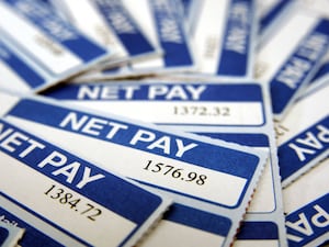 A pile of white and blue payslips showing net pay