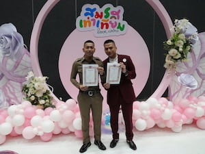 Pisit Sirihirunchai, left, and Chanatip Sirihirunchai from the LGBTQ+ community show their marriage certificates after the Marriage Equality Act took effect in Bangkok, Thailand