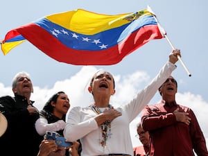 Opposition leader Maria Corina Machado waves a Venezuelan national flag