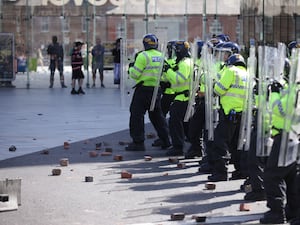 Rubble lies at the feet of police officers thrown by protesters in Liverpool, during disorder on August 3 2024