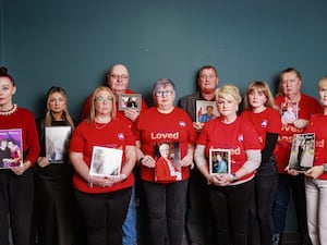 (Left to right) Martina Ferguson, Chanel Gillen, Jennifer Currie, Michael Lusty, Brenda Doherty, Trevor Patterson, Briege McAvoy, Lauren Mallon, Fiona Clarke and Catroina Myles with pictures of loved ones lost during the pandemic at PA Duffy & Co Solicitors offices in Belfast