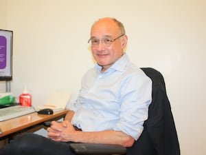 Consultant medical oncologist Professor John Bridgewater in front of his computer at his desk