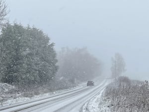 A car driving along a snowy country lane