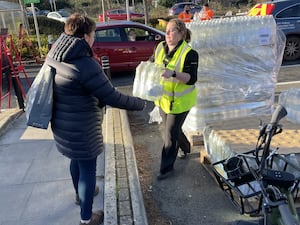 A resident collects water at a bottle station at Asda, Totton, on Thursday