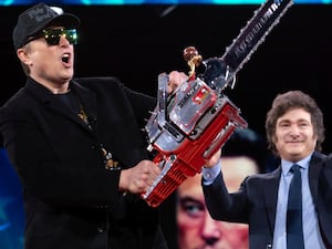 Elon Musk holds up a chainsaw he received from Argentina’s President Javier Milei, right, as they arrive to speak at the Conservative Political Action Conference