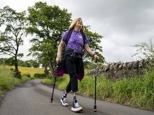 Cor Hutton walking with poles down a country lane