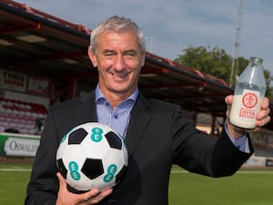 Former Liverpool striker Ian Rush holds a ball and a pint of milk