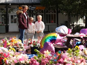 People looking at the floral tributes for the three girls that died in the Southport knife attack