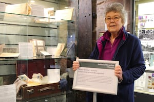 Speaker Susan Davies next to the Shrewsbury Castle display about her great-aunt: ‘Auntie Emmie’s suitcase – A wartime service life unpacked’. 