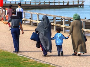 Muslim family walking on the beach