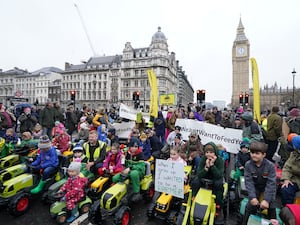 Children on toy tractors leading a march