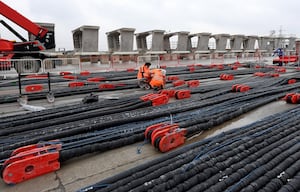 Engineers can be seen working on the cable strays that keeps the structure together