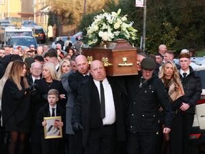 John George's coffin is carried by his family