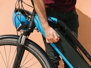 A cyclist securing an e-bike battery