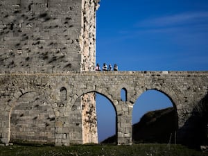 Women sit on a bridge at Krak des Chevaliers on the outskirts of Homs