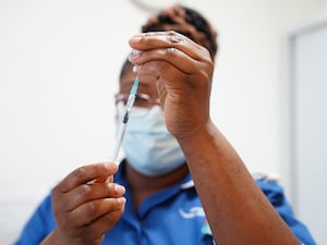 A nurse prepares a dose of a Covid-19 vaccine for Margaret Keenan, 91, prior to her receiving a spring Covid-19 booster shot at University Hospital Coventry.