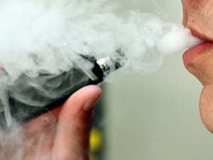 A man exhaling whilst using a vaping product (PA)