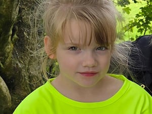 Hope Gordon wearing a fluorescent green top, looking at the camera from beneath a long blonde fringe