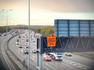 Protesters on a gantry over the M25