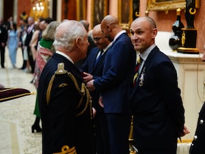 The King presents the Humanitarian Medal to Matthew Newport during a medal presentation at Buckingham Palace