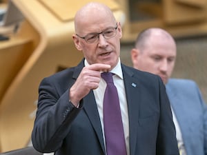 John Swinney standing while speaking in Holyrood