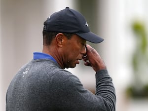 Tiger Woods wipes his face