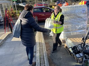 A resident collects water at a bottle station at Asda in Totton