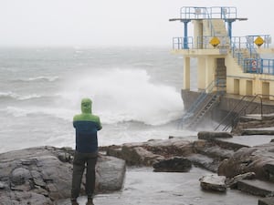 A person watches the waves at the Blackrock diving tower in Salthill, Galway