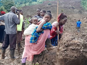 Rescue workers and people search for bodies after a landslide following heavy rains that buried 40 homes in the mountainous district of Bulambuli, eastern Uganda