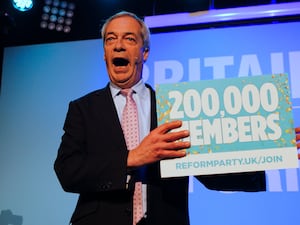 Nigel Farage holds a sign that says 200,000 members