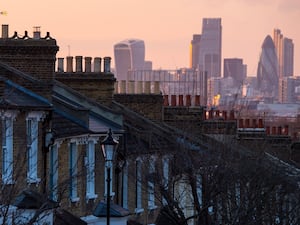 A view of townhouse roofs with London's skyline in the distance