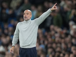 Pep Guardiola gestures on the touchline during a game