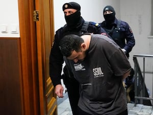 Akhmadzhon Kurbonov on his way into court with guards