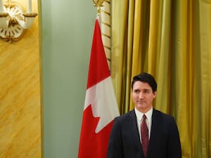 Justin Trudeau before a Canadian flag