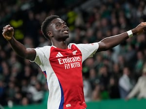 Bukayo Saka lifts his arms out to celebrate scoring