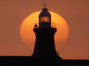 The sun rises behind South Shields lighthouse, on the North East coast