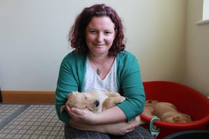 Fiona holding a guide dog puppy.