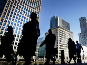 Office workers and commuters walk through Canary Wharf