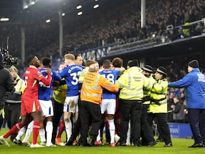 Liverpool and Everton players confront each other on the pitch