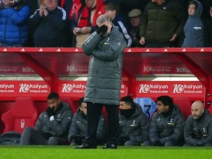 Ange Postecoglou covers his eyes as he stands in the dugout