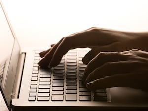 A woman’s hands on a laptop keyboard.