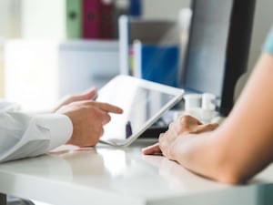 A doctor with a tablet and patient