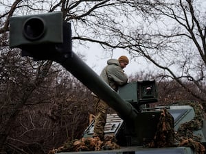 A Ukrainian serviceman of Azov brigade stands atop a self-propelled howitzer Dita after firing towards Russian positions in the Donetsk region, Ukraine