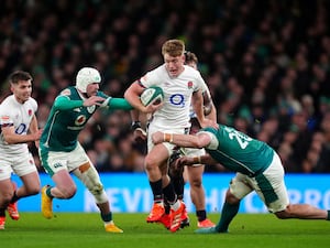 England’s Fin Smith tackled by Ireland’s Mack Hansen and Jack Conan