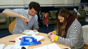 Volunteers repair an iron at a repair cafe