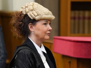 Dorothy Bain in court dressed in wig and gown, looking off to the right