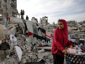 A Palestinian woman hangs laundry in the ruins of her family home in Jabaliya, Gaza Strip